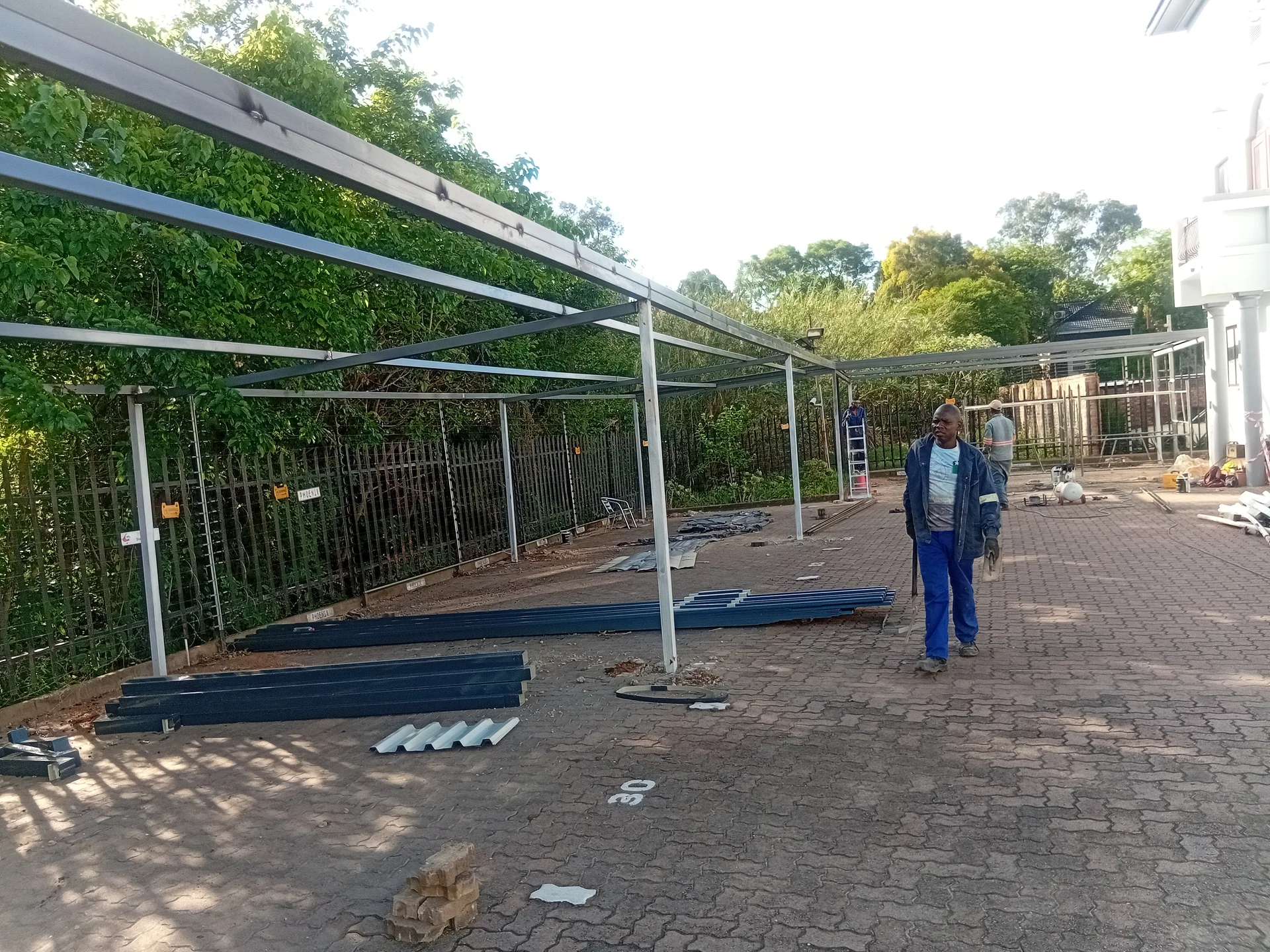 Completed steel carport over a paved driveway